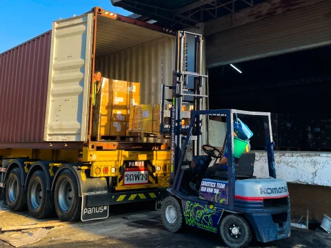 Forklift loading boxes into a shipping container